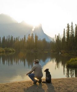 chien et son maître à côté d'un lac